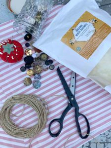 scissors, needle, wax, buttons, small rope, fabric